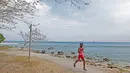 Seorang peserta wanita Rhino Cross Triathlon melintasi pemandangan pantai pada Festival Pesona Tanjung Lesung 2017 di Tanjung Lesung, Banten (24/9/2017). Total jarak tempuh Rhino Cross Triathlon 38 km. (Bola.com/Nicklas Hanoatubun)