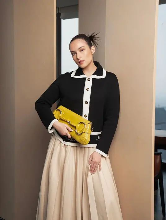 Penampilan classy Chelsea Islan dibalut all Gucci. Atasan sweater hitam yang menis, dipadu dengan pleated midi skirt bernuansa beige, dan platform heels hitam. Chelsea Islan tampak menenteng tas berwarna kuning. [Foto: Instagram/winstongomez]