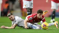 Gelandang Leeds United, Ezgjian Alioski (kiri) dan gelandang Manchester United, Daniel James, terjatuh usai perebutan bola dalam laga lanjutan Liga Inggris 2020/21 pekan ke-14 di Old Trafford Stadium, Minggu (20/12/2020). Leeds United kalah 2-6 dari Manchester United. (AFP/Nick Potts/Pool)