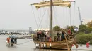 Perahu menderek replika kapal dagang Hellenic dengan bantuan tali di Pelabuhan Haifa, Israel (17/3). Kapal ini ditemukan di lepas Pantai Kibbutz, Israel. (AFP Photo/Jack Guez)