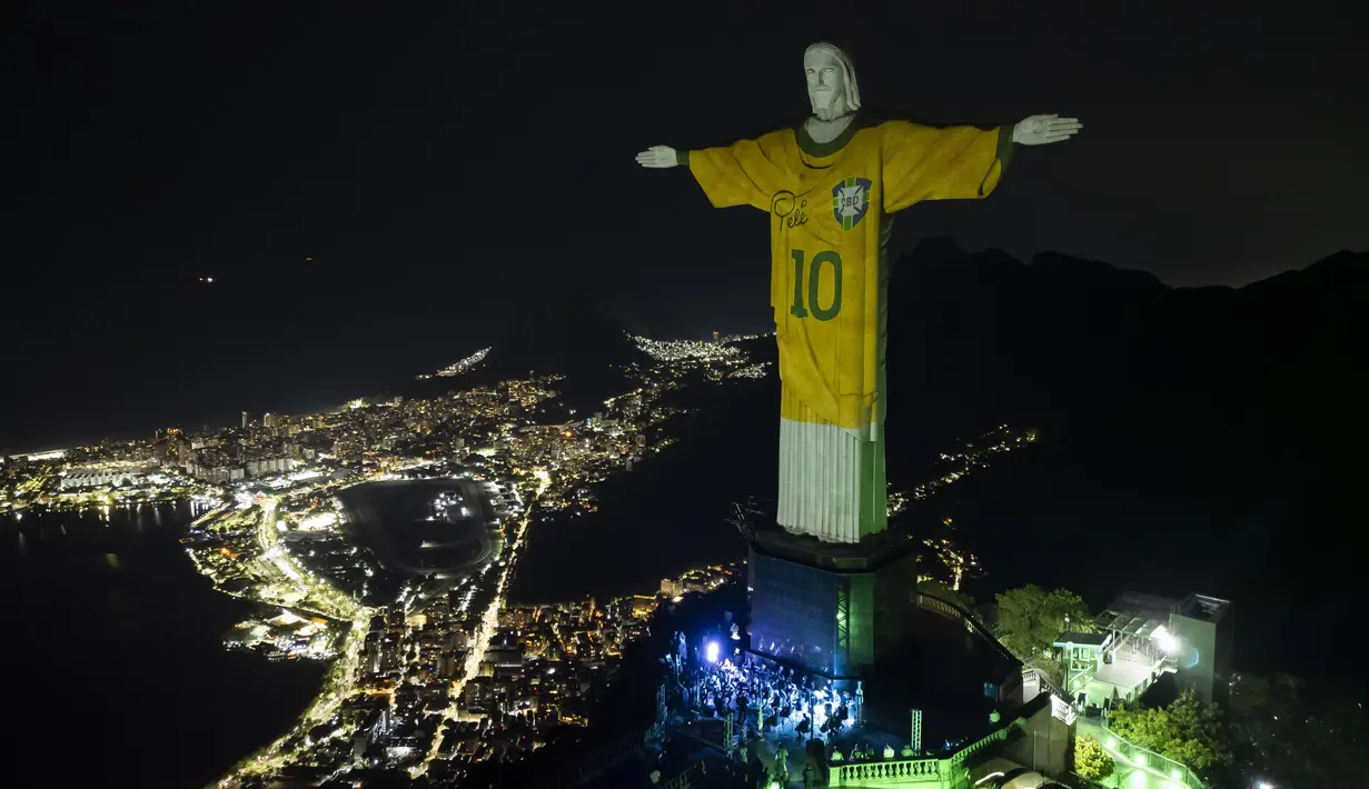 Patung Kristus Sang Penebus diterangi dengan gambar jersey Brasil milik Pele, sebagai penghormatan kepada legenda sepak bola tersebut pada peringatan satu tahun kematiannya, di Rio de Janeiro, Jumat, 29 Desember 2023. (AP Photo/Bruna Prado)