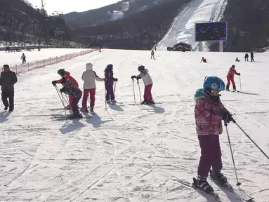 Anak-anak sekolah Korea Utara bersiap untuk bermain ski di resor ski Masik Pass (28/1). Resor ski ini dibangun pada tahun 2013 atas perintah pemimpin Korea Utara Kim Jong Un. (AP Photo / Eric Talmadge)