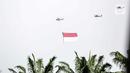 Helikopter TNI AU mengibarkan bendera Merah Putih raksasa di kawasan Gedung DPR RI, Jakarta, Selasa (5/10/2021). TNI AU mengerahkan enam helikopter yang membawa bendera Merah Putih serta bendera Trimatra raksasa. (Liputan6.com/Faizal Fanani)