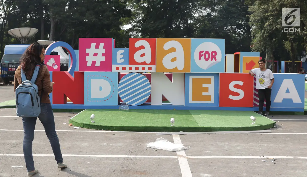 Warga berfoto di depan ornamen jelang pelaksanaan turnamen Indonesia Open 2019 di Istora Senayan, Jakarta, Senin (15/7/2019). Indonesia Open 2019 akan dihelat pada 16-21 Juli 2019. (Liputan6.com/Helmi Fithriansyah)