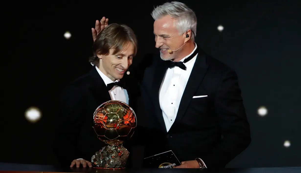 Gelandang Real Madrid, Luka Modric berpose dengan David Ginola setelah memenangkan penghargaan Ballon d'Or 2018 pada malam penganugerahan di Paris, Senin (3/12). Modric menjadi pemain pertama Kroasia yang meraih gelar prestisius ini. (AP/Christophe Ena)