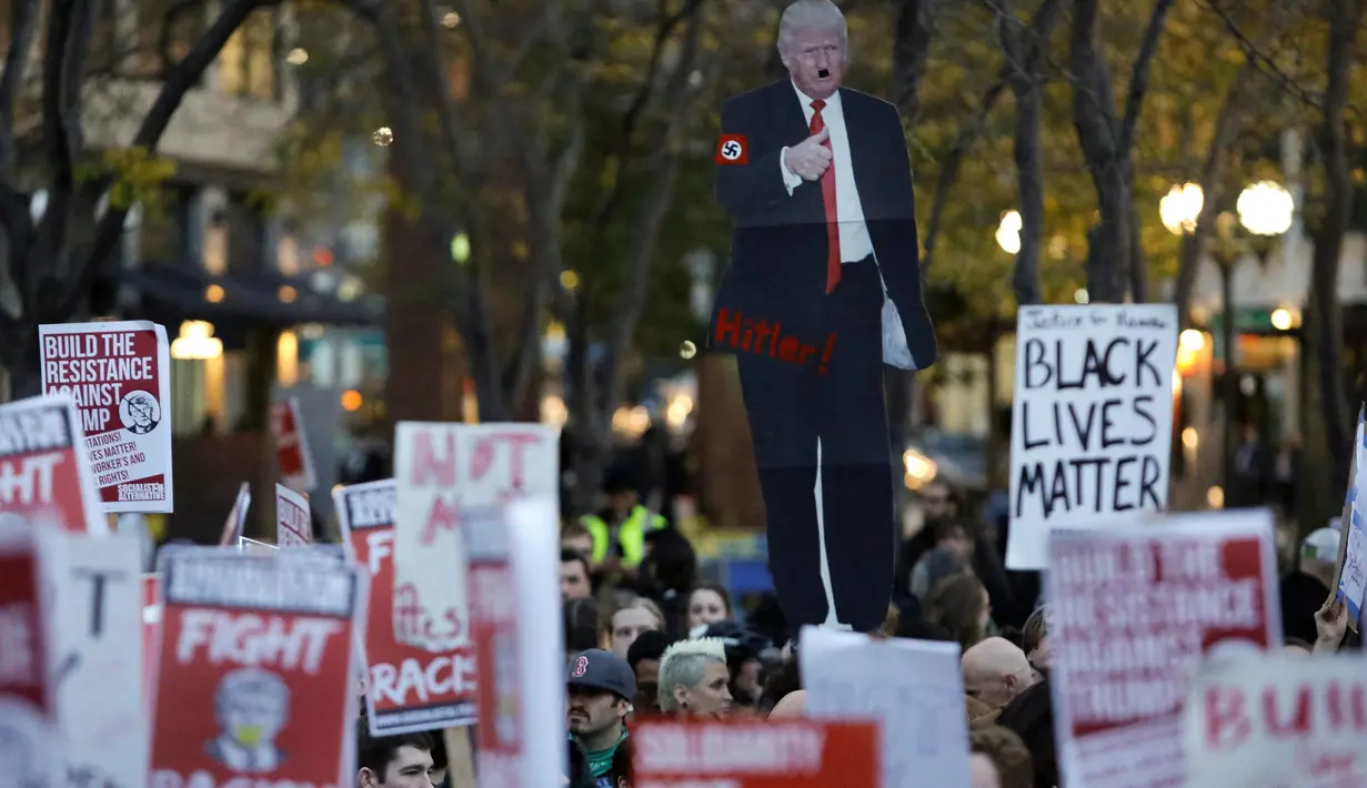 Pengunjuk rasa membawa gambar Donald Trump saat menggelar aksi protes di Seattle, Washington, Rabu (9/11). Ribuan warga Amerika Serikat  turun ke jalan untuk memprotes kemenangan Donald Trump dalam pemilihan Presiden AS. (REUTERS/Jason Redmond)
