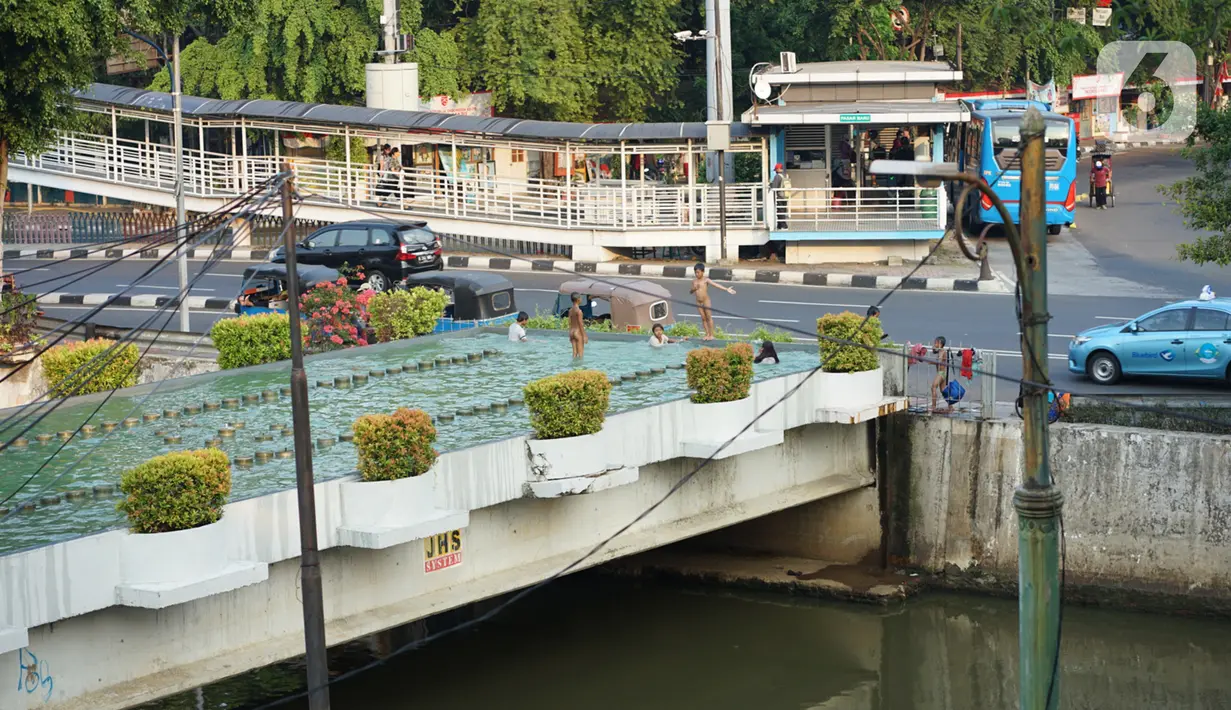 Anak-anak berenang di kolam penghias taman Pasar Baru di Jakarta, Rabu (2/9/2020). Meskipun terdapat larangan, namun sejumlah anak tetap nekat berenang di kolam tersebut sehingga mengganggu ketertiban umum. (Liputan6.com/Immanuel Antonius)