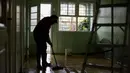 Seorang pria membersihkan rumahnya yang dilanda banjir di lingkungan Sarandi, salah satu daerah yang paling parah dilanda hujan lebat di Porto Alegre, negara bagian Rio Grande do Sul, Brasil, pada tanggal 27 Mei 2024. (Anselmo Cunha/AFP)