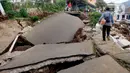 Warga melintas di jalan yang rusak parah pascagempa bumi magnitudo 5,6 di Kampung Cisarua, Desa Sarampad, Kabupaten Cianjur, Jawa Barat, Rabu (23/11/2022). Kepala BNPB Letjen TNI Suharyanto mengonfirmasi korban meninggal akibat gempa Kabupaten Cianjur, Jawa Barat, berjumlah 268 orang. (merdeka.com/Arie Basuki)