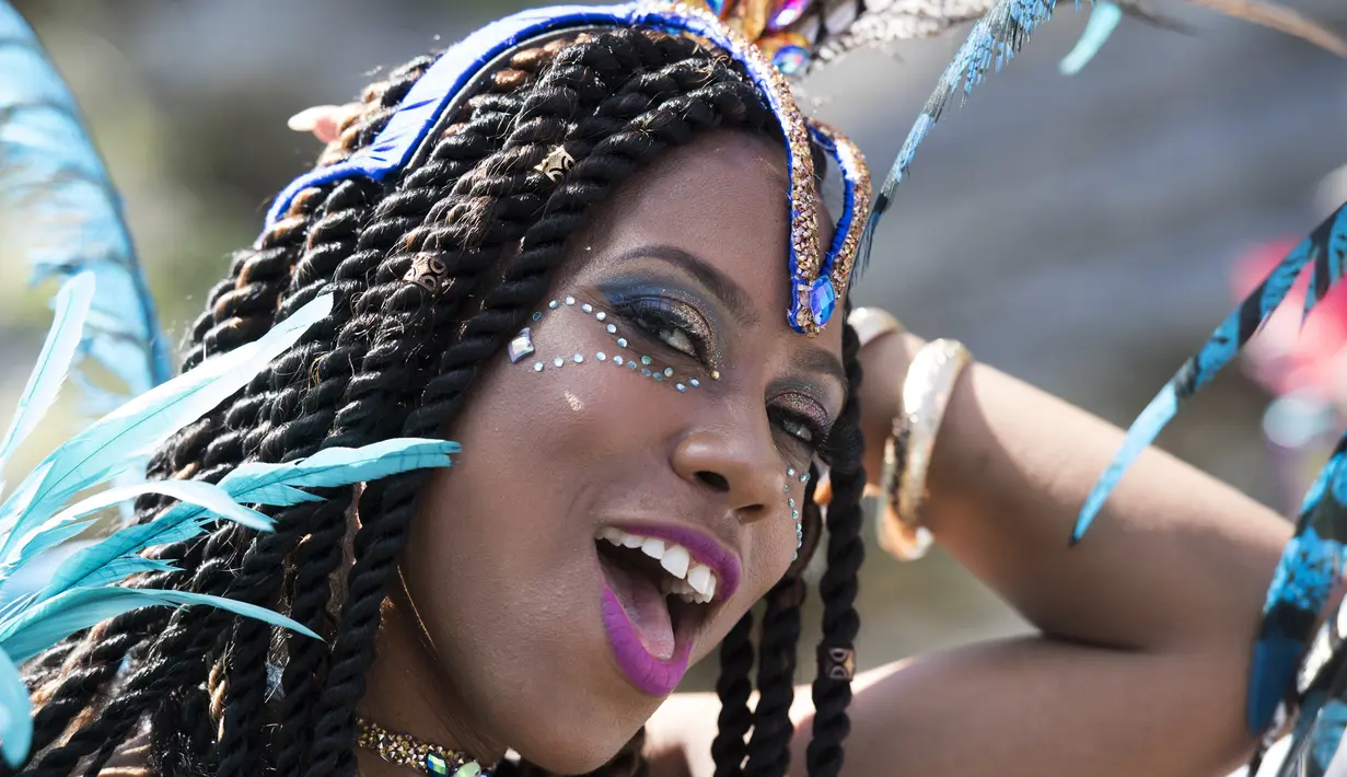 Ekspresi seorang penari yang mengenakan kostum saat difoto sebelum mengikuti perayaan Hari Pahlawan Nasional di St. David's, Bermuda (19/6). (AFP Photo/Don Emmert)