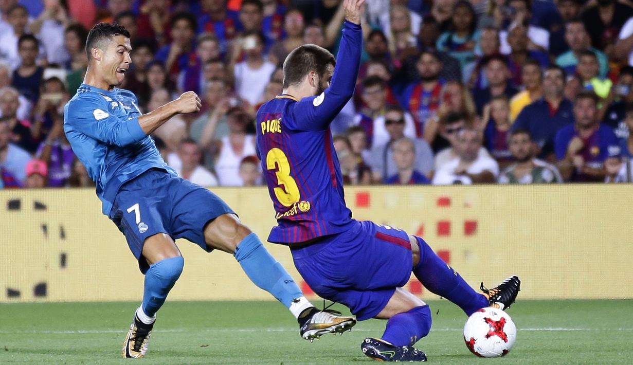 Aksi Ronaldo melewati adangan pemain FC Barcelona, Gerard Pique (kanan) pada laga Supercup Spanyol di Camp Nou stadium, Barcelona, (13/8/2017). Real Madrid menang 3-1. (AP/Manu Fernandez)