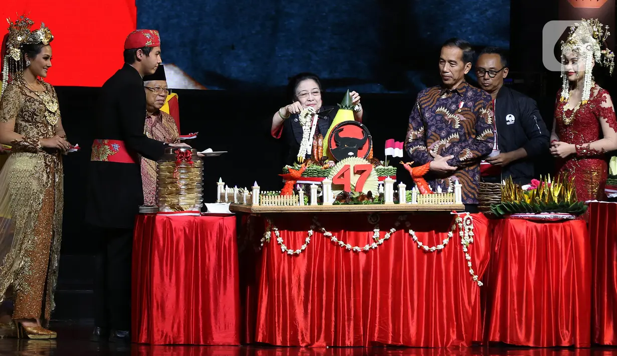 Ketua Umum PDI Perjuangan Megawati Soekarnoputri (tengah) memotong tumpeng disaksikan Presiden Joko Widodo (ketiga kanan) dan Wakil Presiden Ma'ruf Amin (ketiga kiri) saat pembukaan Rakernas I dan HUT ke-47 PDIP di JIEXPO Kemayoran, Jakarta, Jumat (10/1/2020). (Liputan6.com/Johan Tallo)