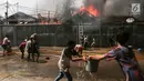 Warga mencoba memadamkan api yang membakar pemukiman padat penduduk di kawasan Manggarai, Jakarta, Rabu (10/7/2019). Tidak ada laporan korban dalam kebakaran ini, sementara kerugian yang diderita masih dalam penanganan petugas di lokasi. (Kapanlagi.com/Budy Santoso)