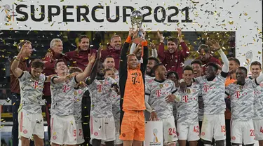 Kiper Bayern Manuel Neuer memegang trofi di depan timnya setelah memenangkan pertandingan Supercup Jerman melawan Borussia Dortmund di Signal Iduna Park Dortmund, Jerman, Rabu (18/8/2021). Munchen berhasil meraih gelar Piala Super Jerman usai mengalahkan atas Dortmund 3-1. (AP Photo/Martin Meissner)