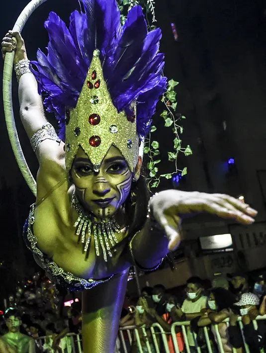 Seorang wanita tampil selama parade Mitos dan Legenda di Medellin, Kolombia (8/12/2021). Parade mitos dan legenda adalah bagian penting dari acara ini di sebagian besar kota dan kotamadya Kolombia. (AFP/Joaquin Sarmiento)
