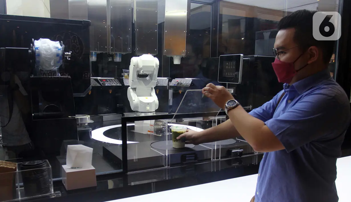 Pelanggan mengambil pesanan minuman buatan robot barista di Family Mart, Grand Indonesia East Mall, Jakarta, Senin (10/1/2022). FamilyMart Indonesia meluncurkan pengoperasian robot barista yang mampu membuat minuman untuk pelanggan dalam waktu satu hingga dua menit. (merdeka.com/Arie Basuki)