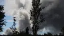 Seorang wanita melihat asap tebal yang berembus dari puncak gunung berapi Kilauea di Hawaii. 15 Mei 2018. Para wisatawan tetap santai dan justru menjadikan letusan gunung ini sebagai objek wisata. (MARIO TAMA/GETTY IMAGES NORTH AMERICA/AFP)