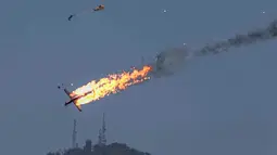 Dua pesawat Wong Bee KT-1B milik TNI AU bertabrakan hingga membuat ledakan dan terbakar jelang pameran Dirgantara Langkawi, Malaysia, Minggu (14/3/2015). Para pilot terlihat menyelamatkan diri dengan dengan parasut. (Dailymail)