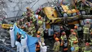 Tim SAR mencari korban di antara puing-puing bangunan yang runtuh di Gwangju, Korea Selatan (9/6/2021). Puing bangunan itu tampak jatuh dan mengubur sebagian ruas jalan. (AFP/Yonhap)