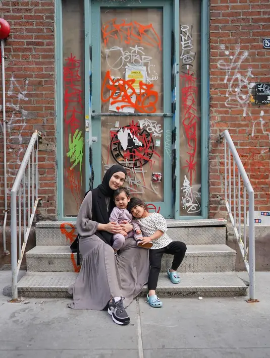 Kali ini, Dwi Handayani tampil dengan outfit lebih kasual. Dwi Handayani berpose dengan kedua buah hatinya mengenakan long dress abu-abu gelap dan syal hitam, sedangkan anaknya mengenakan outfit set berwarna ungu muda dan atasan bermotif mini floral dan legging hitam. Foto: Instagram.