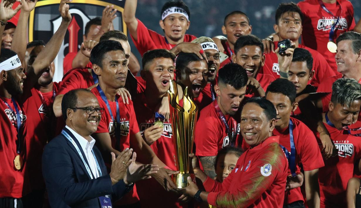 Kapten Bali United, Fadhil Sausu, menerima trofi gelar juara Liga 1 2019 di Stadion Kapten I Wayan Dipta, Bali, Minggu (22/12). Bali berada di peringkat satu dengan meraih 64 poin. (Bola.com/Aditya Wany)