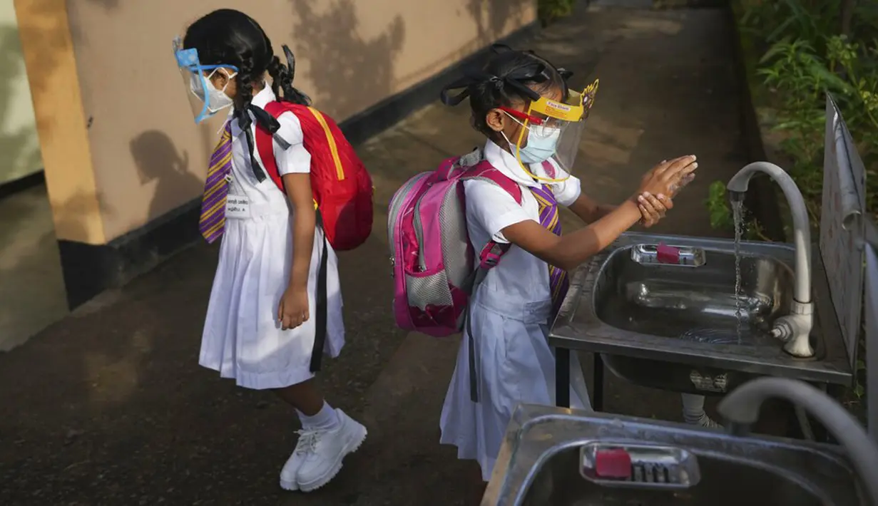 Para siswa sekolah dasar mencuci tangan sebelum memasuki ruang kelas di sebuah sekolah di Kolombo, Sri Lanka, 25 Oktober 2021. Sri Lanka memulai kembali semua sekolah dasar yang telah ditutup lebih dari enam bulan karena pandemi COVID-19. (AP Photo/Eranga Jayawardena)