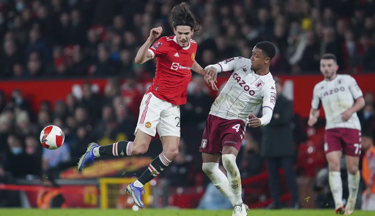 Penyerang Manchester United, Edinson Cavani berebut bola dengan pemain Aston Villa, Ezri Konsa pada pertandingan putaran ketiga Piala FA di stadion Old Trafford di Manchester, Inggris, Selasa (11/1/2022). MU menang atas Aston Villa 1-0. (AP Photo/Jon Super)