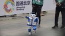 Sebuah robot humanoid berkompetisi dalam ajang lari half marathon yang berlangsung di Beijing, China, Sabtu (19/04/2025). (AP Photo/Ng Han Guan)
