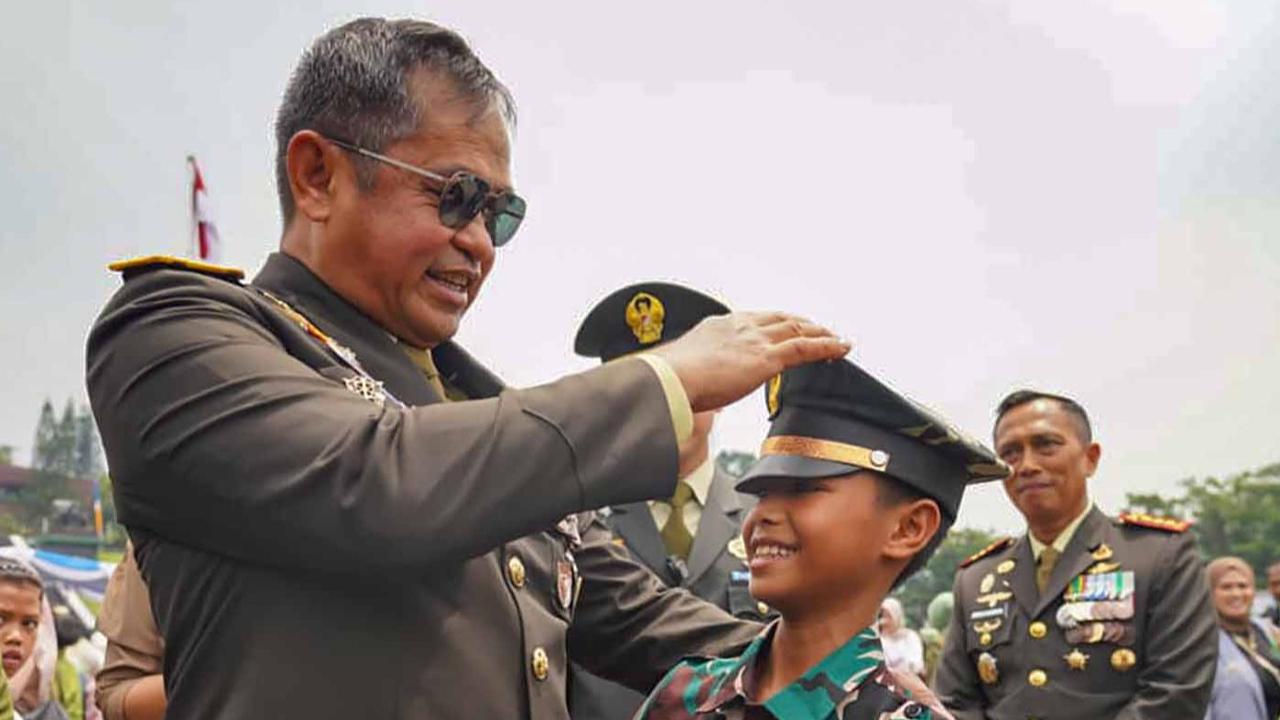 FOTO: Momen Akrab Kasad Maruli Simanjuntak Kenakan Topi Berpuncak kepada Seorang Anak
