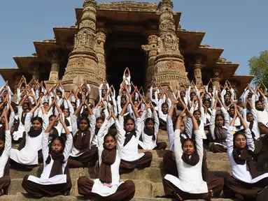 Siswa sekolah India mengambil bagian dalam sesi yoga untuk menandai Hari Yoga Internasional di Kuil Matahari di Modhera, dekat kota Mahesana sekitar 100 km dari Ahmedabad di negara bagian Gujarat, (21/6). (AFP Photo/Sam Panthaky)
