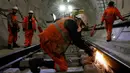 Seorang pekerja mengelas jalur kereta api saat menyelesaikan pembuatan proyek Crossrail di Stepney, London, Inggris, (16/11). Proyek ini memiliki panjang sekitar 180 kilometer. (REUTERS/Stefan Wermuth)