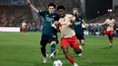 Penyerang Lens #09 Elye Wahi (kanan) berebut bola dengan bek Arsenal #18 Takehiro Tomiyasu pada laga matchday 2 Grup B Liga Champions 2023/2024 yang digelar di Stade Bollaert-Delelis, Rabu (4/10/2023) dini hari WIB. (Sameer Al-Doumy / AFP)