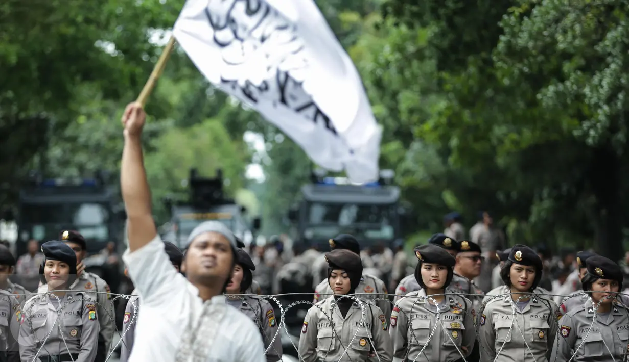 Polisi wanita (Polwan) berdiri di depan massa aksi 31 Maret yang berkumpul di kawasan Jalan Merdeka Barat, Jumat (31/3). Para polwan dari Brimob Polda Metro Jaya tersebut dikerahkan dalam pengamanan aksi 31 Maret. (Liputan6.com/Faizal Fanani)