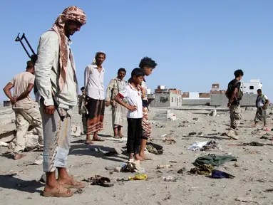 Sejumlah orang berkumpul di lokasi bom bunuh diri di sebuah pangkalan militer kota Aden, Yaman, Minggu (18/12). Sedikitnya 43 tentara tewas dalam serangan yang terjadi seminggu setelah serangan militan ISIS yang menewaskan 50 tentara (SALEH AL-OBEIDI/AFP)