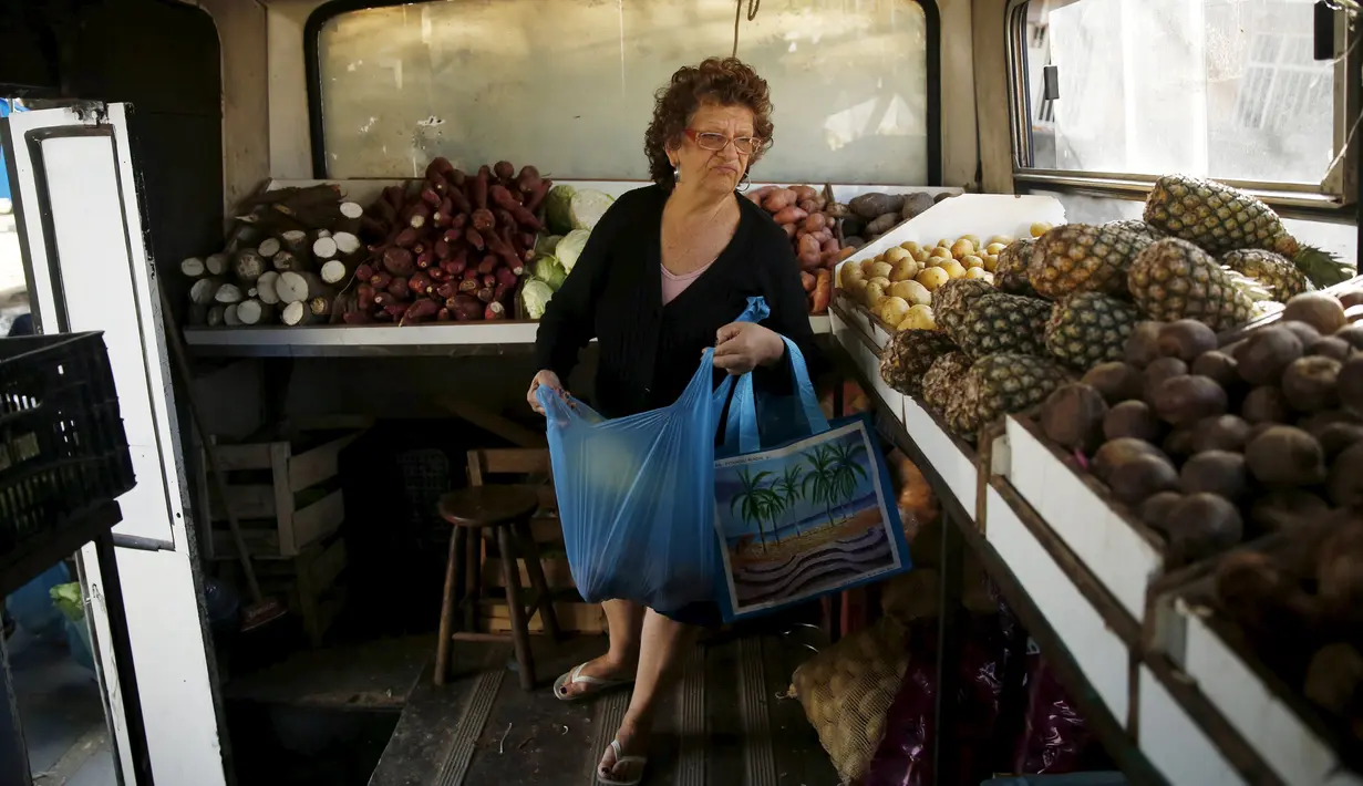 Seorang wanita berbelanja buah-buahan di dalam pasar bus 'Sacolao' di Santa Teresa, Rio de Janeiro, Brasil, Selasa (7/7/2015). Pasar bus ini menjual sayur dan buah-buahan dengan harga yang terjangkau. (REUTERS/Pilar Olivares)