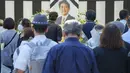 Orang-orang meninggalkan bunga dan memberi penghormatan kepada mantan Perdana Menteri Jepang Shinzo Abe menjelang pemakaman kenegaraannya di Tokyo, Selasa, 27 September 2022. Abe meninggal usai ditembak Tetsuya Yamagami saat menyampaikan pidato di sekitar Stasiun Nara pada awal Juli lalu. (Nicolas Datiche/Pool Photo via AP)