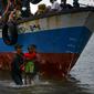 Nelayan Aceh membantu evakuasi seorang anak pengungsi etnis Rohingya menuju pesisir pantai desa Lancok, di Kabupaten Aceh Utara, Kamis (25/6/2020). Hampir 100 orang etnis Rohingya, termasuk 30 orang anak-anak ditemukan terdampar di tengah laut dengan kondisi kapal rusak. (CHAIDEER MAHYUDDIN/AFP)