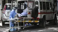 Staf rumah sakit mengambil jenazah dari ambulans di kamar mayat di New Delhi, India, Senin (24/5/2021). Kematian akibat COVID-19 di India telah menembus 300 ribu orang. (Money SHARMA/AFP)