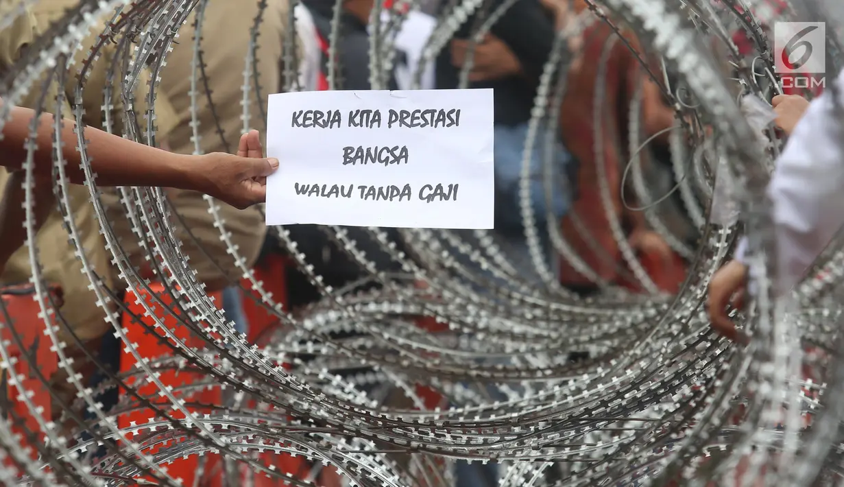Massa honorer K2 menunjukkan membawa kertas bertulis aspirasi saat berunjuk rasa di depan Istana Merdeka, Jakarta, Selasa (30/10). Mereka juga meminta diangkat menjadi PNS tanpa tes dan tanpa batasan usia. (Liputan6.com/Angga Yuniar)
