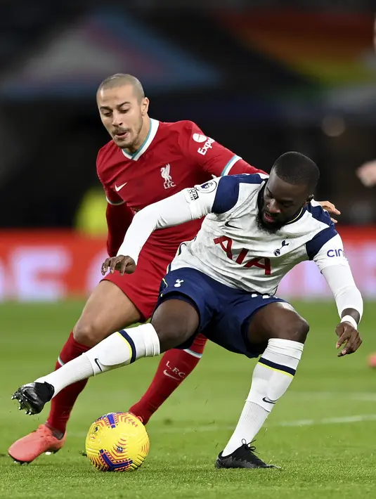 Gelandang Liverpool, Thiago berusaha merebut bola dari gelandang Tottenham Hotspur, Tanguy Ndombele pada pertandingan lanjutan Liga Inggris di Stadion Tottenham Hotspur, London, Jumat (29/1/2021). Kemenangan tersebut membuat Liverpool kembali ke peringkat 4 klasemen. (Shaun Botterill/Pool via AP)
