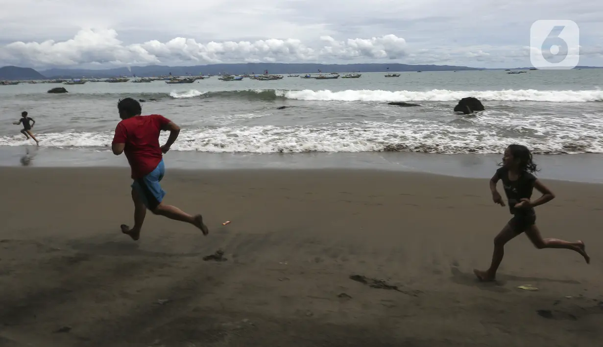 Warga bermain di Pantai Pelabuhan Ratu, Kabupaten Sukabumi, Jawa Barat, Jumat (12/11/2021). Penerapan Pemberlakuan Pembatasan Kegiatan Masyarakat (PPKM) Level 1 membolehkan objek wisata kembali buka, salah satunya Pantai Pelabuhan Ratu. (Liputan6.com/Johan Tallo)