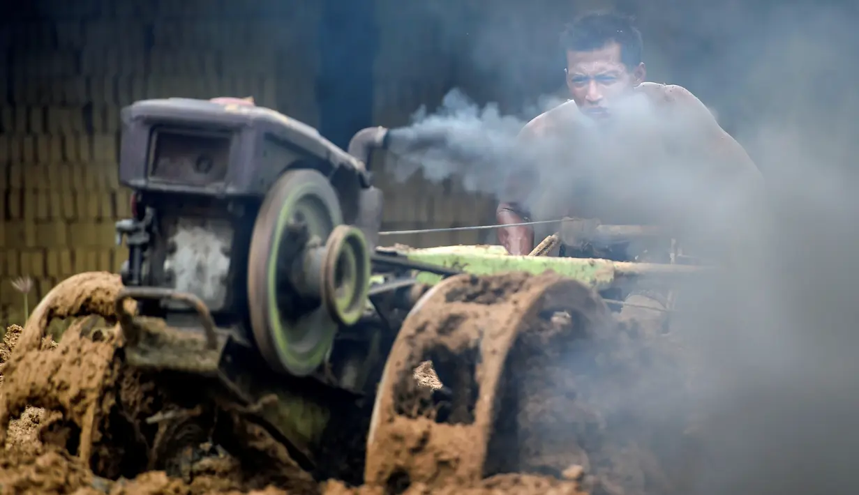 Seorang pria mencampur bahan untuk membuat batu bata di sebuah pabrik batu bata di pinggiran Kajhu, Provinsi Aceh (18/11/2020). (AFP/Chaideer Mahyuddin)