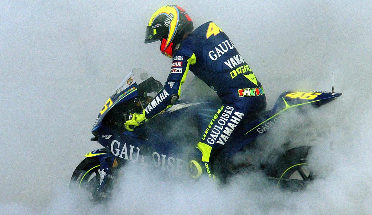 Valentino Rossi melakukan burnout ketika merayakan kemenangan dalam balapan MotoGP di sirkuit Ricardo Tormo, Spanyol pada 31 Oktober 2004. (AFP/Jose Jordan)