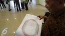 Seorang tenaga ahli konstruksi mengamati denah Stadion Gedebage, Bandung, Rabu (10/6/2015). Penyidik Dirtipidkor Polri dan sejumlah tenaga ahli mengecek fisik stadion dalam kasus korupsi pembangunan Stadion Gedebage (Liputan6.com/Awan Harinto)