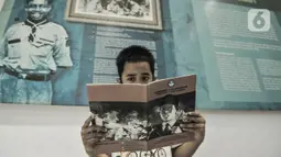 Seorang anak membaca buku panduan sejarah saat mengunjungi Museum Sumpah Pemuda, Jakarta, Rabu (28/10/2020). Libur cuti bersama dimanfaatkan untuk mengajak anak-anak mengenal sejarah lahirnya Sumpah Pemuda agar memahami jejak perjuangan pahlawan sejak dini. (merdeka.com/Iqbal Nugroho)
