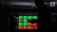 Pekerja melintas di dekat layar digital pergerakan saham di Gedung BEI, Jakarta, Rabu (14/10/2020). Pada pembukaan perdagangan pukul 09.00 WIB, IHSG masih naik, namun tak lama kemudian, IHSG melemah 2,3 poin atau 0,05 persen ke level 5.130, 18. (Liputan6.com/Angga Yuniar)