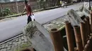 Warga melintas di samping pagar yang ambruk di Taman Hutan Tebet, Jakarta, Kamis (28/3). Kondisi pagar yang ambruk akibat hujan deras tersebut butuh perbaikan karena telah terabaikan selama beberapa bulan terakhir. (Liputan6.com/Immanuel Antonius)