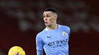 Gelandang Manchester City, Phil Foden mengontrol bola saat bertanding melawan Liverpool pada pertandingan lanjutan Liga Inggris di Stadion Anfield, Inggris, Senin (8/2/2021).  City menang telak atas Liverpool 4-1. (Laurence Griffiths/Pool via AP)