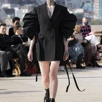 Sarah Burton, Creative Director Alexander McQueen berusaha menginterpretasikan London sebagai tempat hidup dan bekerjanya dan perempuan dari kacamata brand ini sendiri, lewat koleksi SS 2022. Coat bermodel double-breasted dari wol hitam dengan lengan poly faille. Foto: Document/Alexander McQueen.