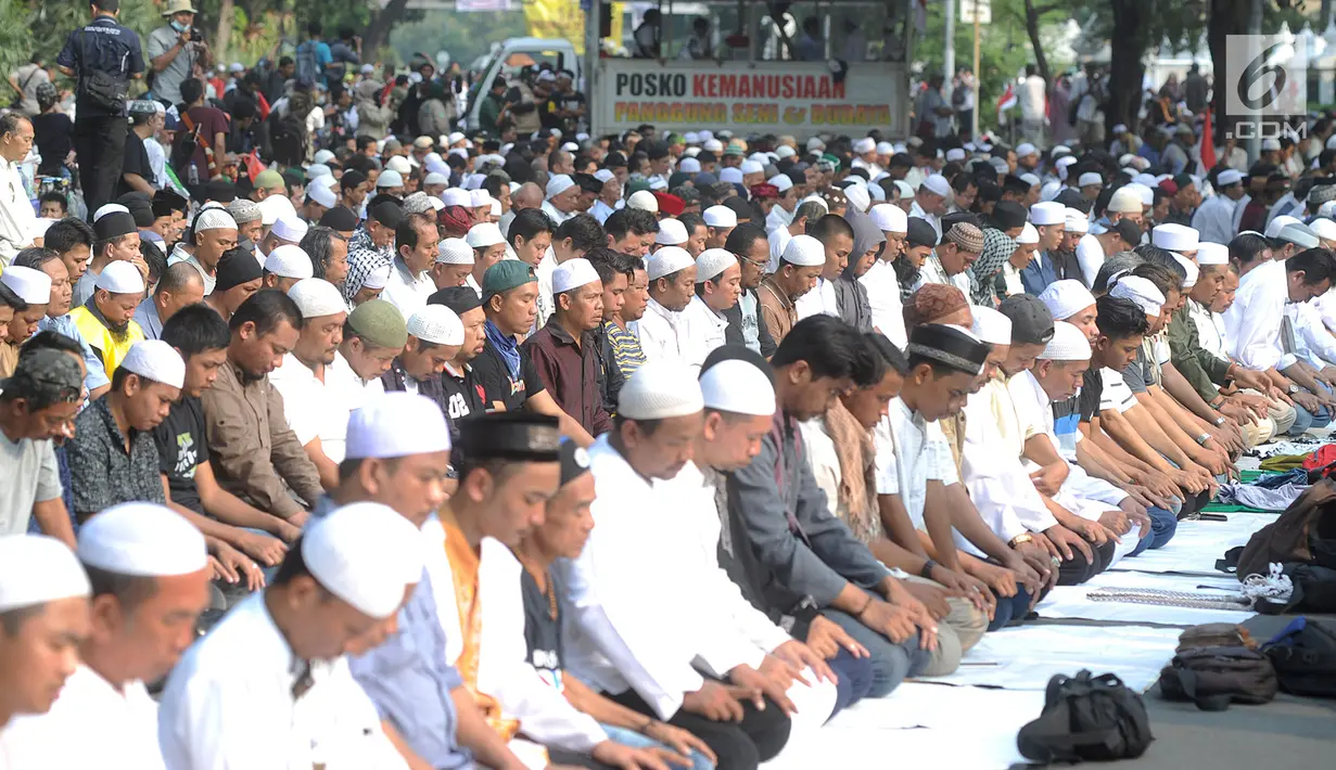Massa pendukung pasangan capres-cawapres Prabowo Subianto dan Sandiaga Uno melakukan salat asar di Jalan Medan Merdeka Barat, Jakarta, Kamis (27/6/2019). Aksi tersebut dilakukan jelang putusan perselisihan hasil pemilihan umum (PHPU) Pilpres 2019 di Gedung MK. (merdeka.com/Arie Basuki)